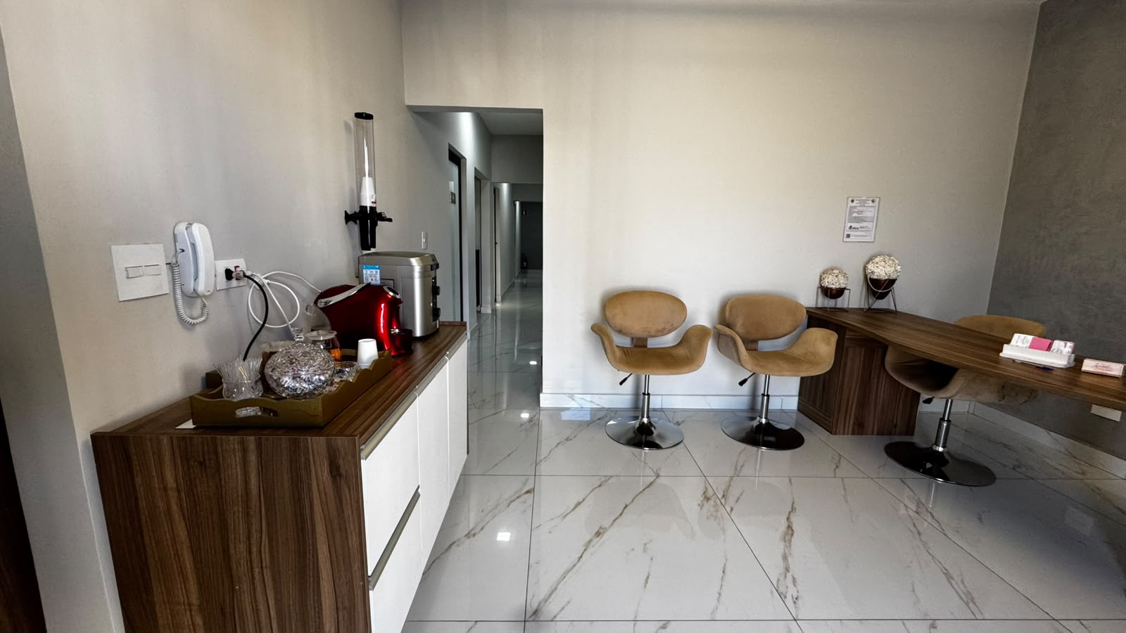 Área de espera com poltronas e balcão de apoio