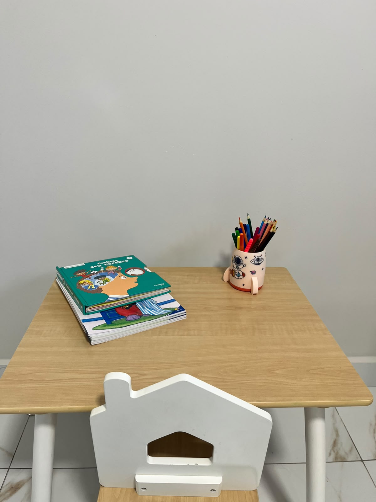 Mesa infantil com livros e lápis de cor na sala de atendimento