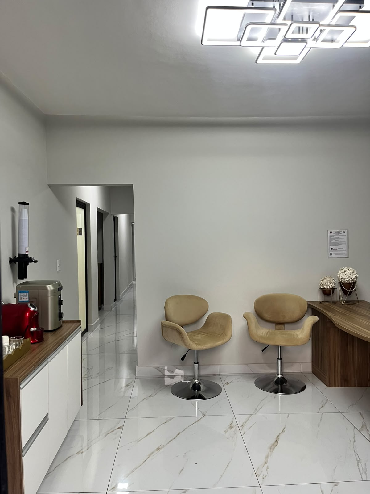 Recepção da clínica com estação de café e poltronas de espera